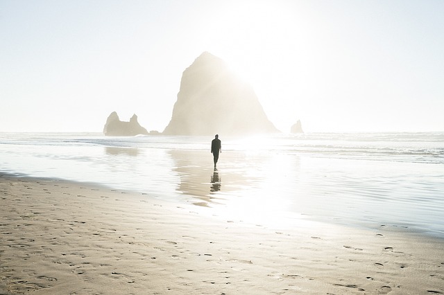 Solitary man walking on a misty beach